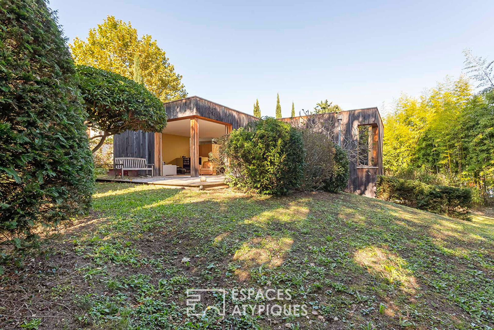 House with a flat green roof in a wooden frame, sheltered from view