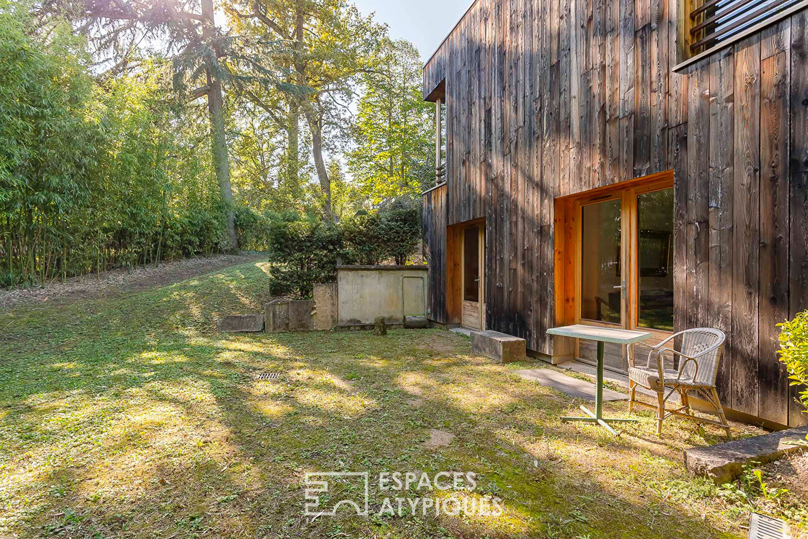 House with a flat green roof in a wooden frame, sheltered from view