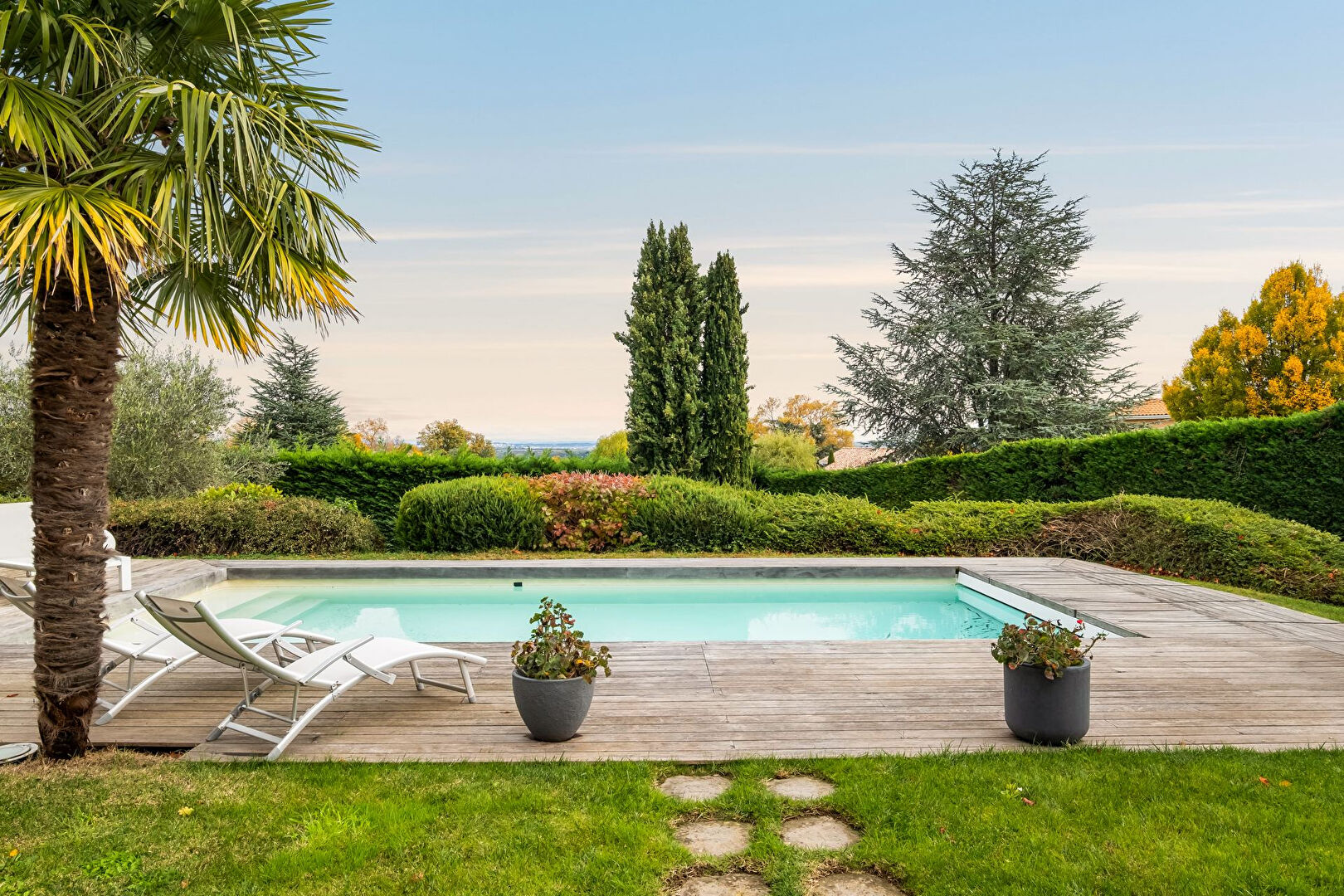 Bright house with swimming pool and tennis court in a green setting with no overlooking neighbors.