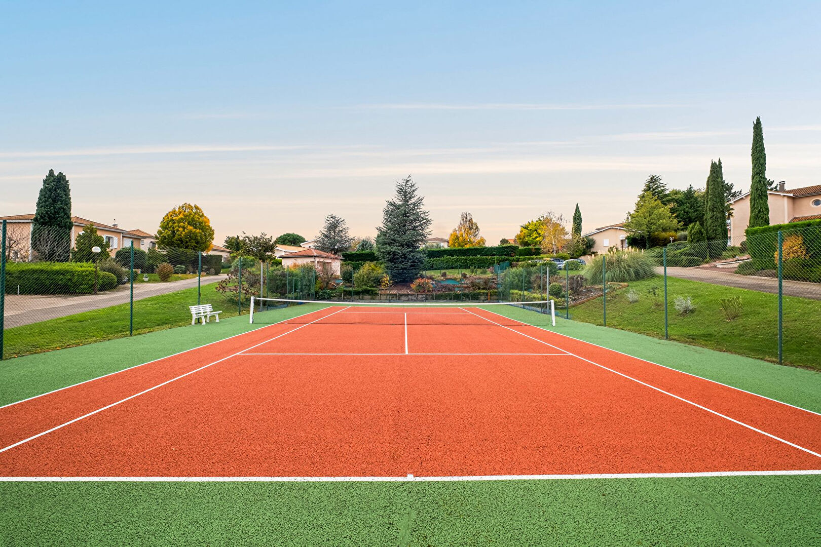Bright house with swimming pool and tennis court in a green setting with no overlooking neighbors.