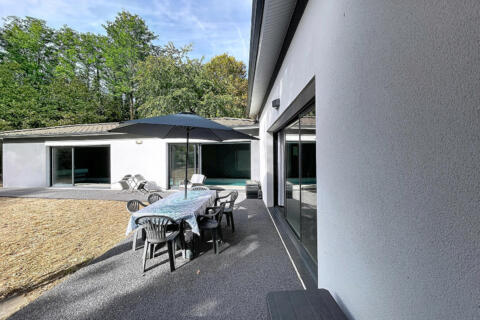 Maison contemporaine de plain-pied avec piscine intérieure et jardin