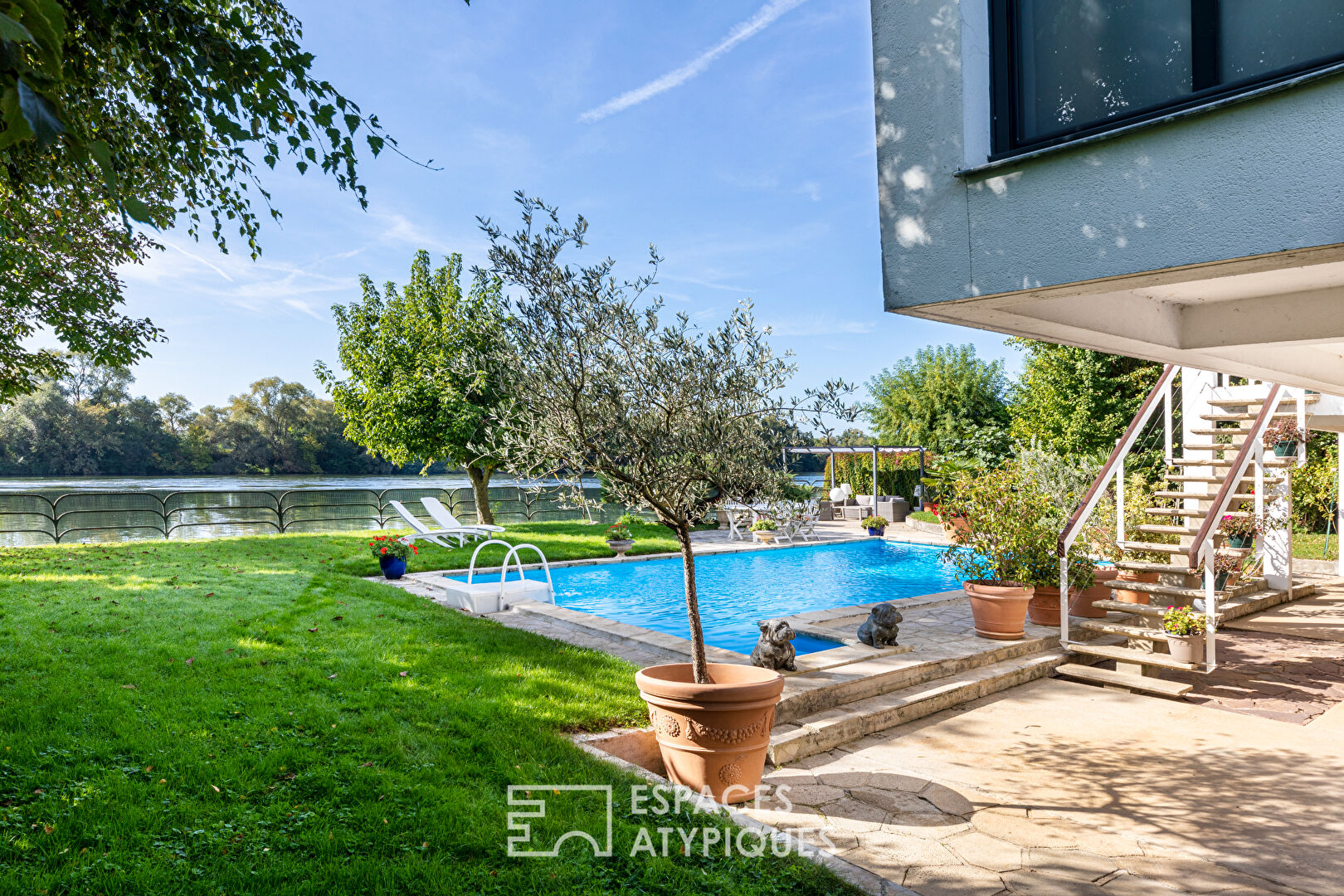 Villa d’architecte sur une ile privée : piscine et ponton en bord de Seine