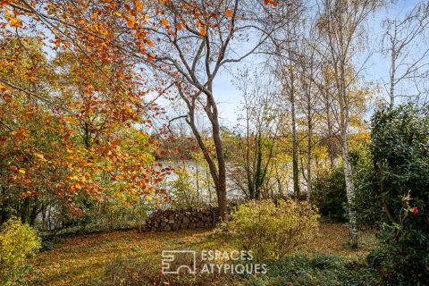 House with contemporary extension on an island and its wooded garden