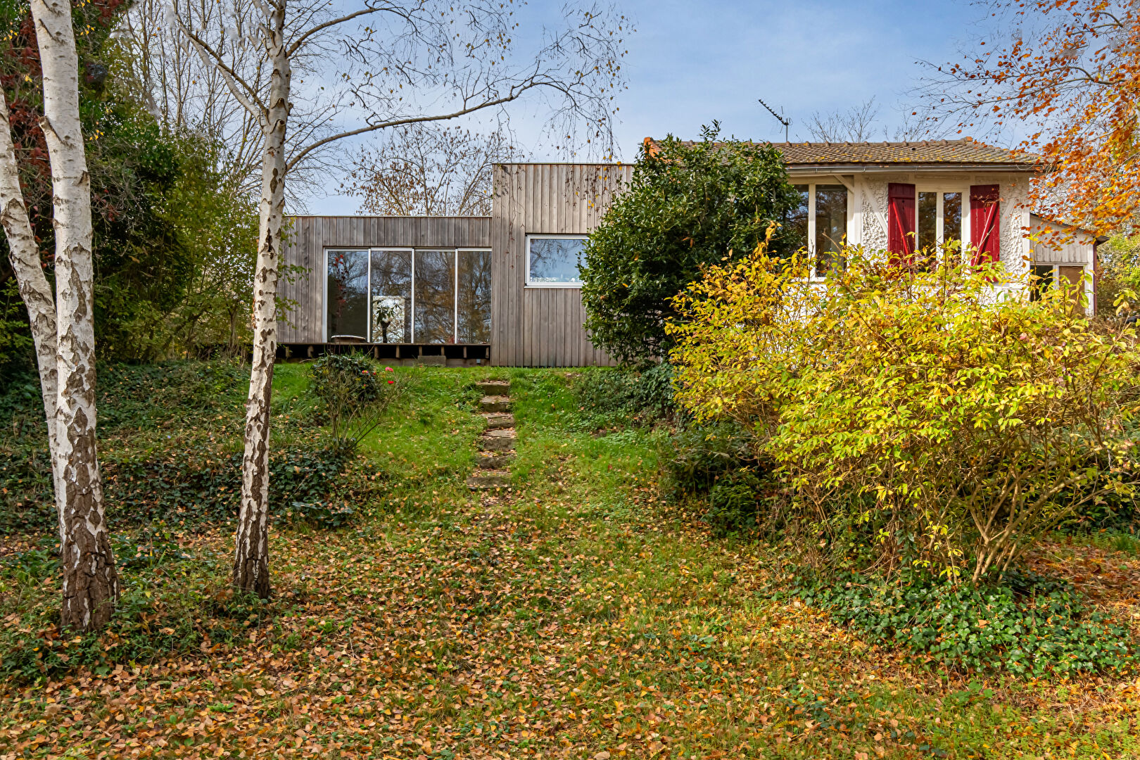 House with contemporary extension on an island and its wooded garden