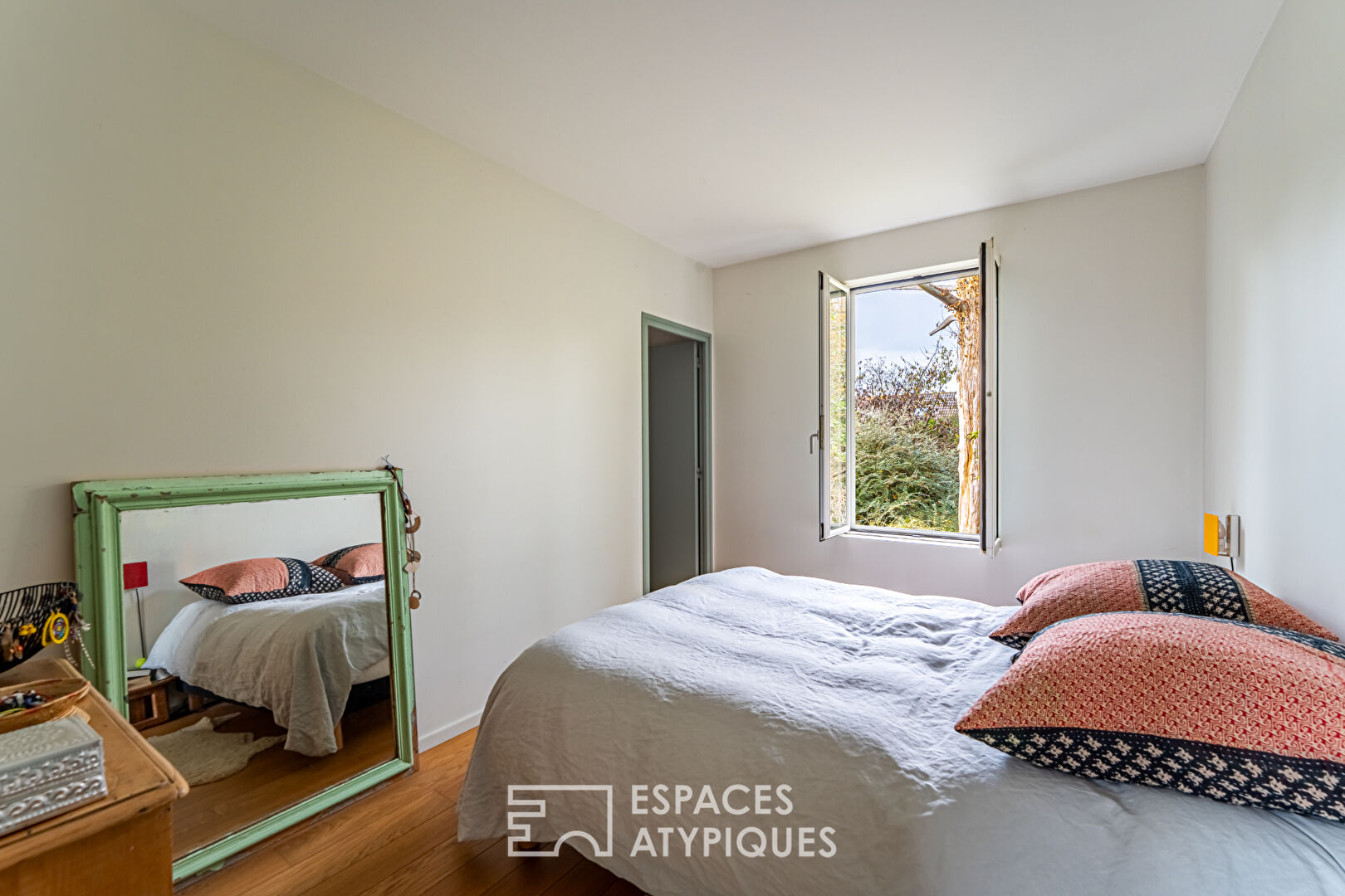 House with contemporary extension on an island and its wooded garden