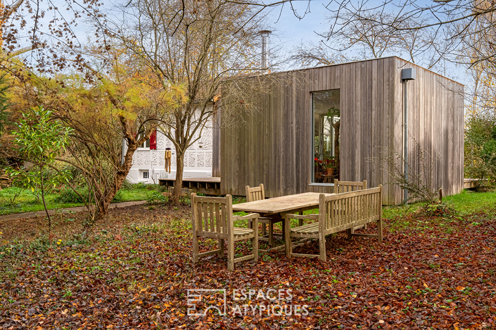 House with contemporary extension on an island and its wooded garden