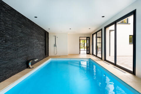 Maison contemporaine avec piscine intérieure et jardin paysager