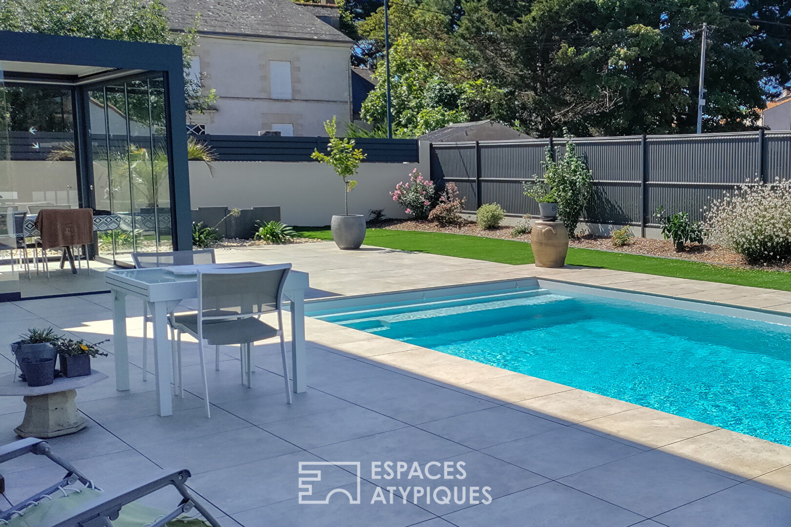 Maison contemporaine autour d’une terrasse paysagée avec piscine