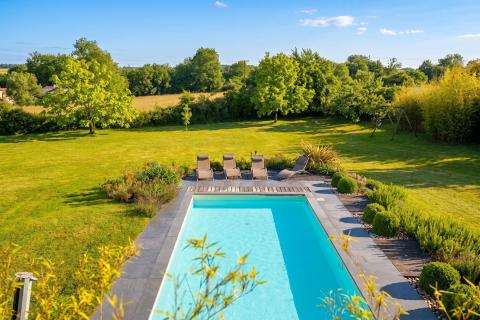 Maison d’architecte avec piscine dans son écrin de verdure.