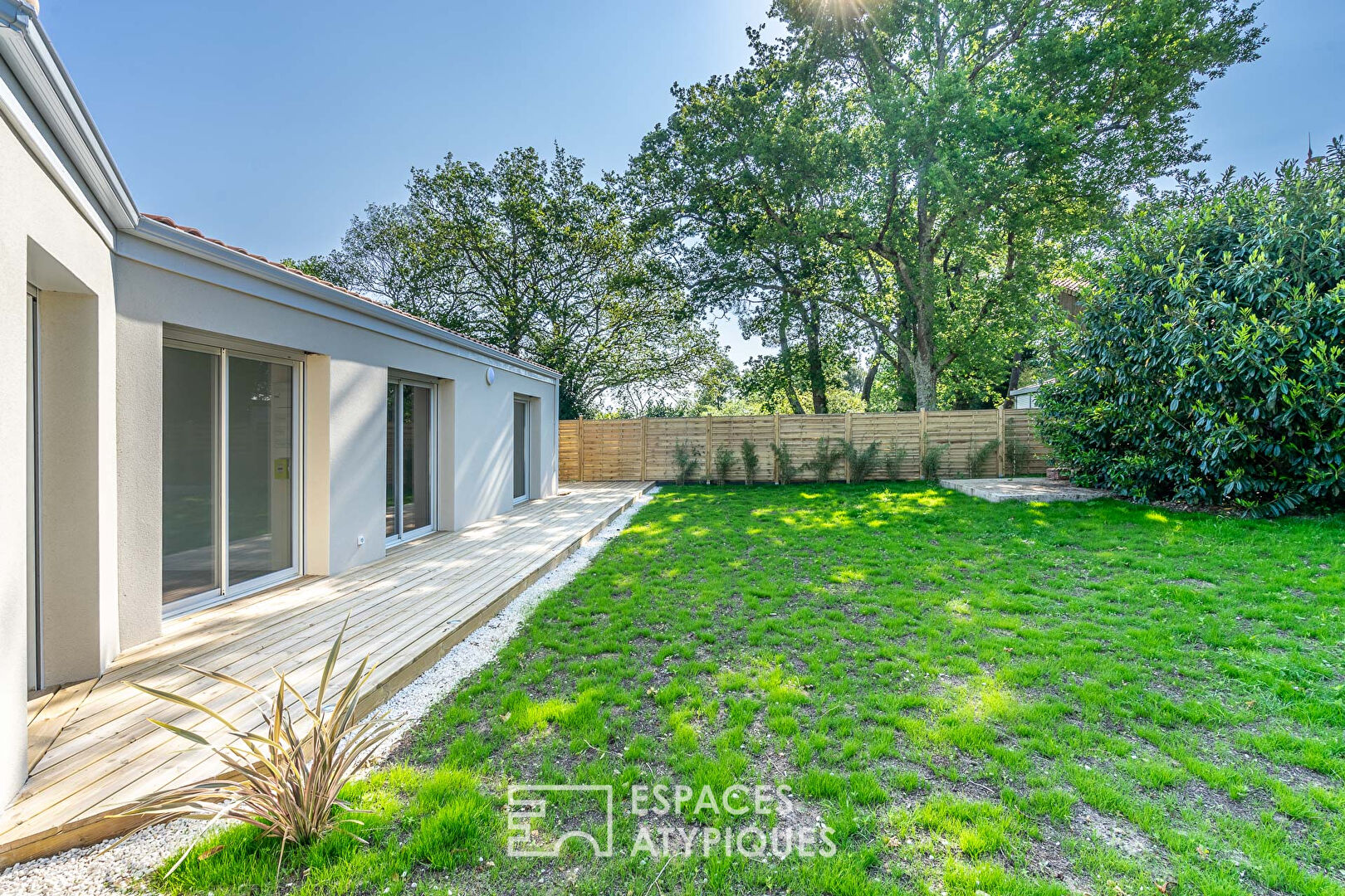 Maison moderne de plain pied avec terrasse et jardin en bord de mer