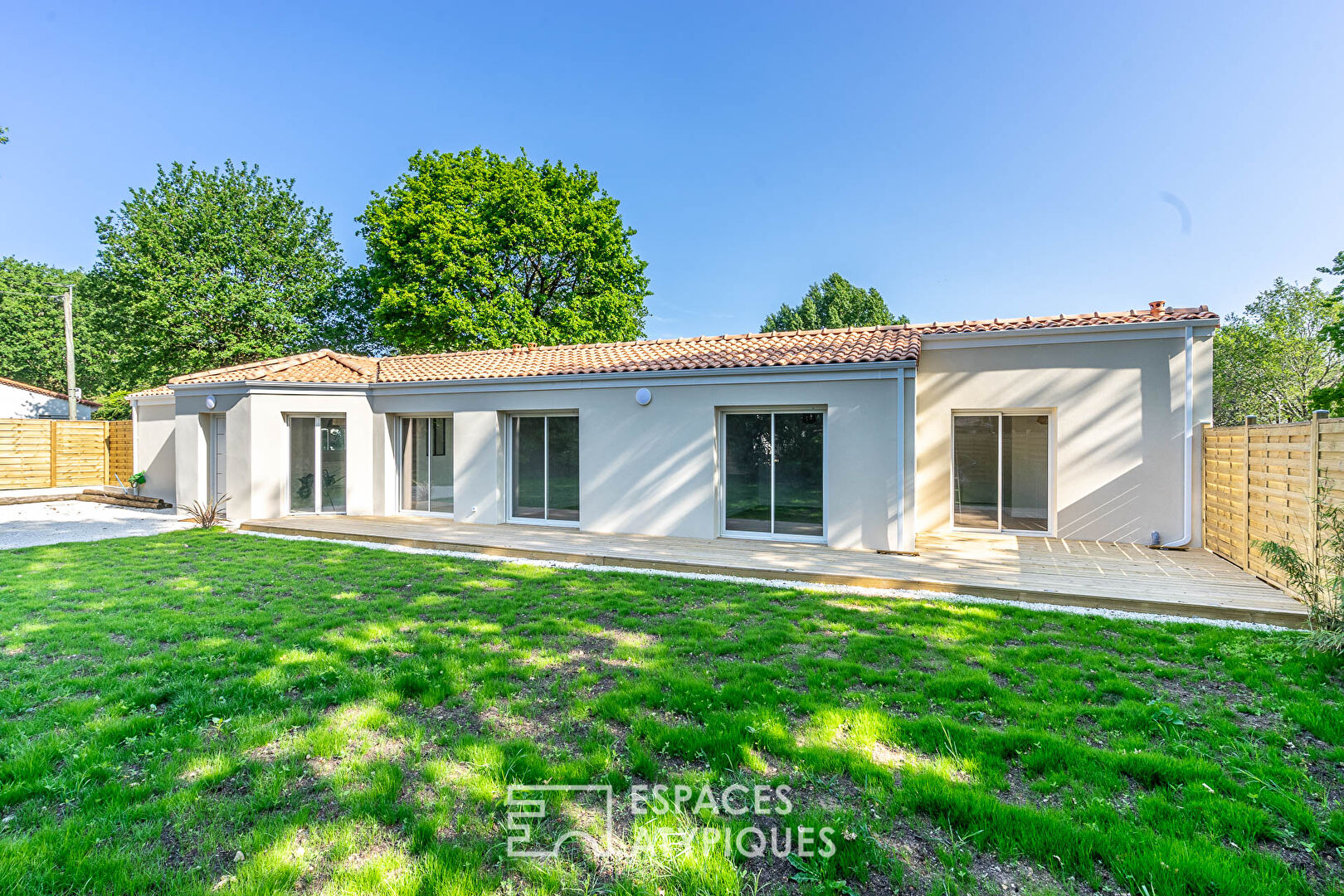 Maison moderne de plain pied avec terrasse et jardin en bord de mer