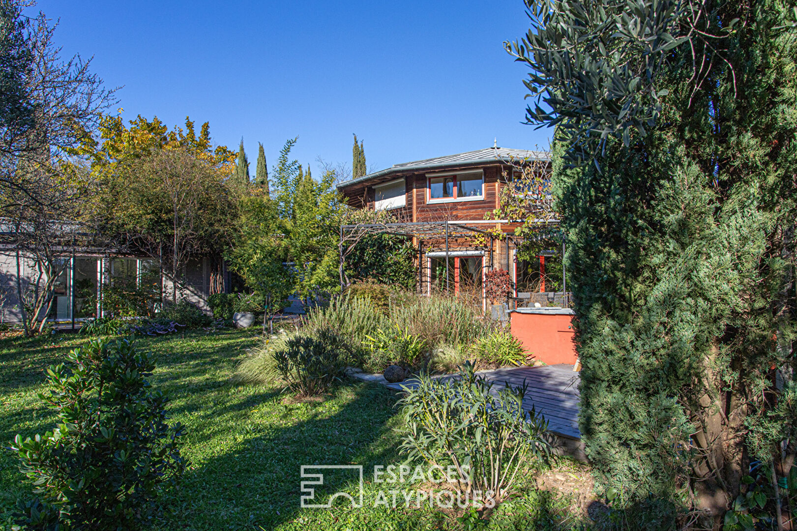 Maison ossature bois, nichée dans son écrin de verdure