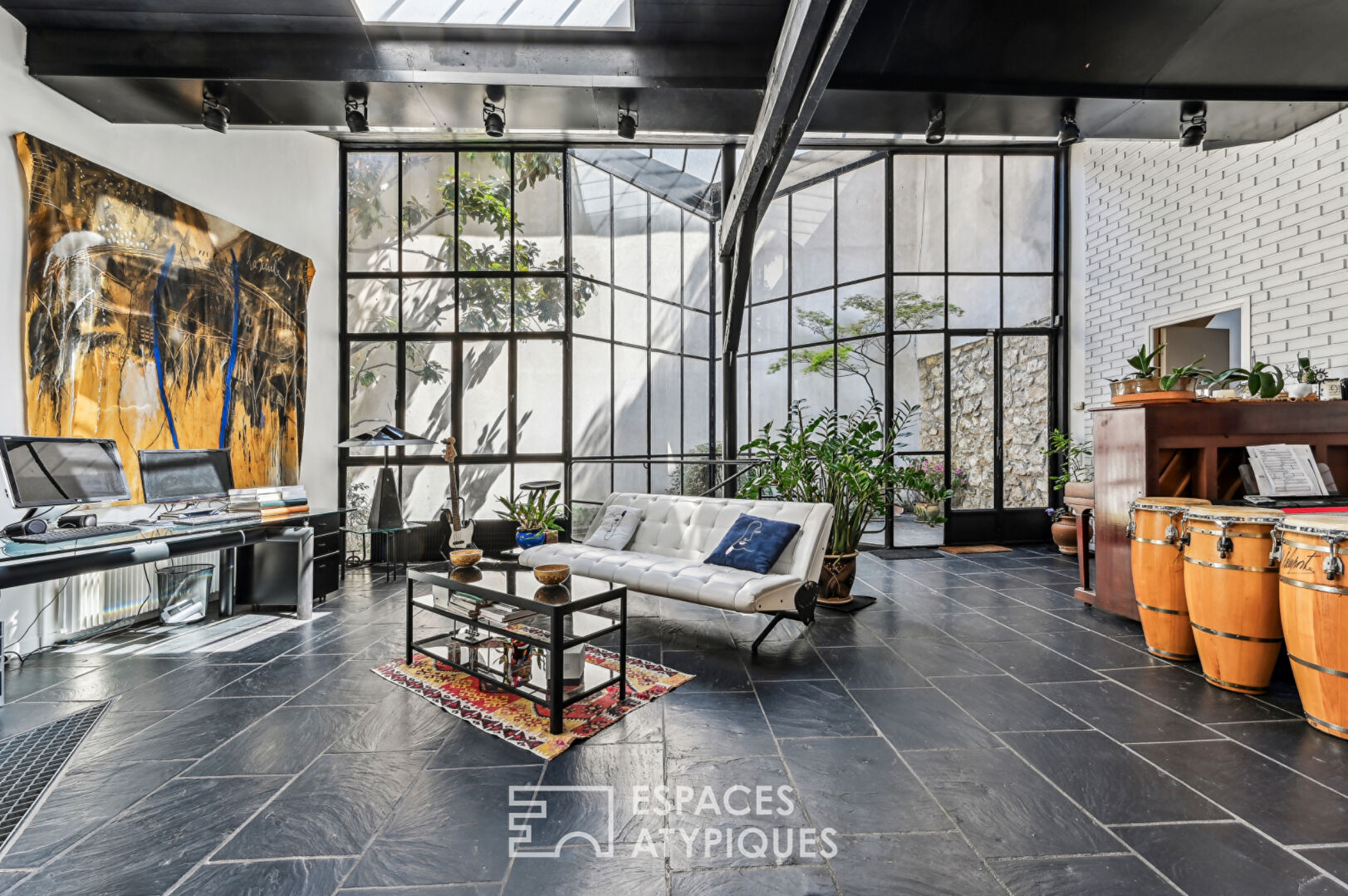 Loft with a glass roof, reminiscent of an artist’s studio, overlooking a courtyard and terrace near the Jardin des Plantes
