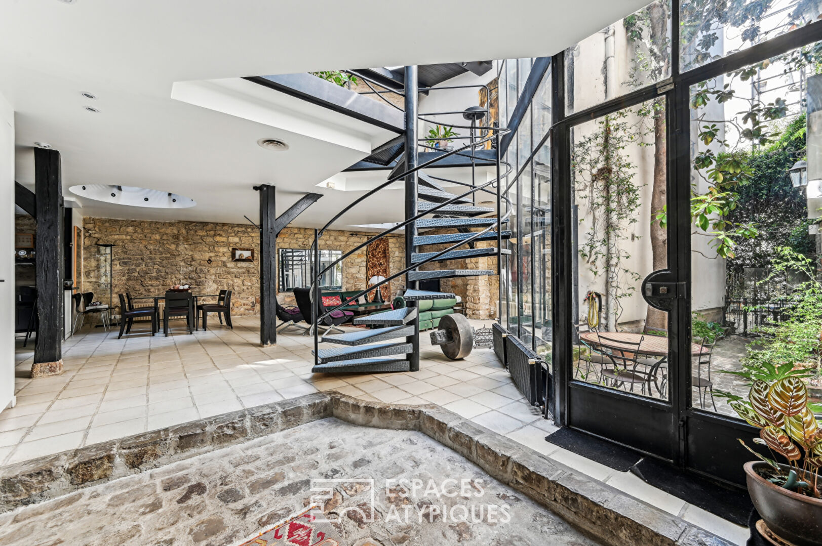 Loft with a glass roof, reminiscent of an artist’s studio, overlooking a courtyard and terrace near the Jardin des Plantes