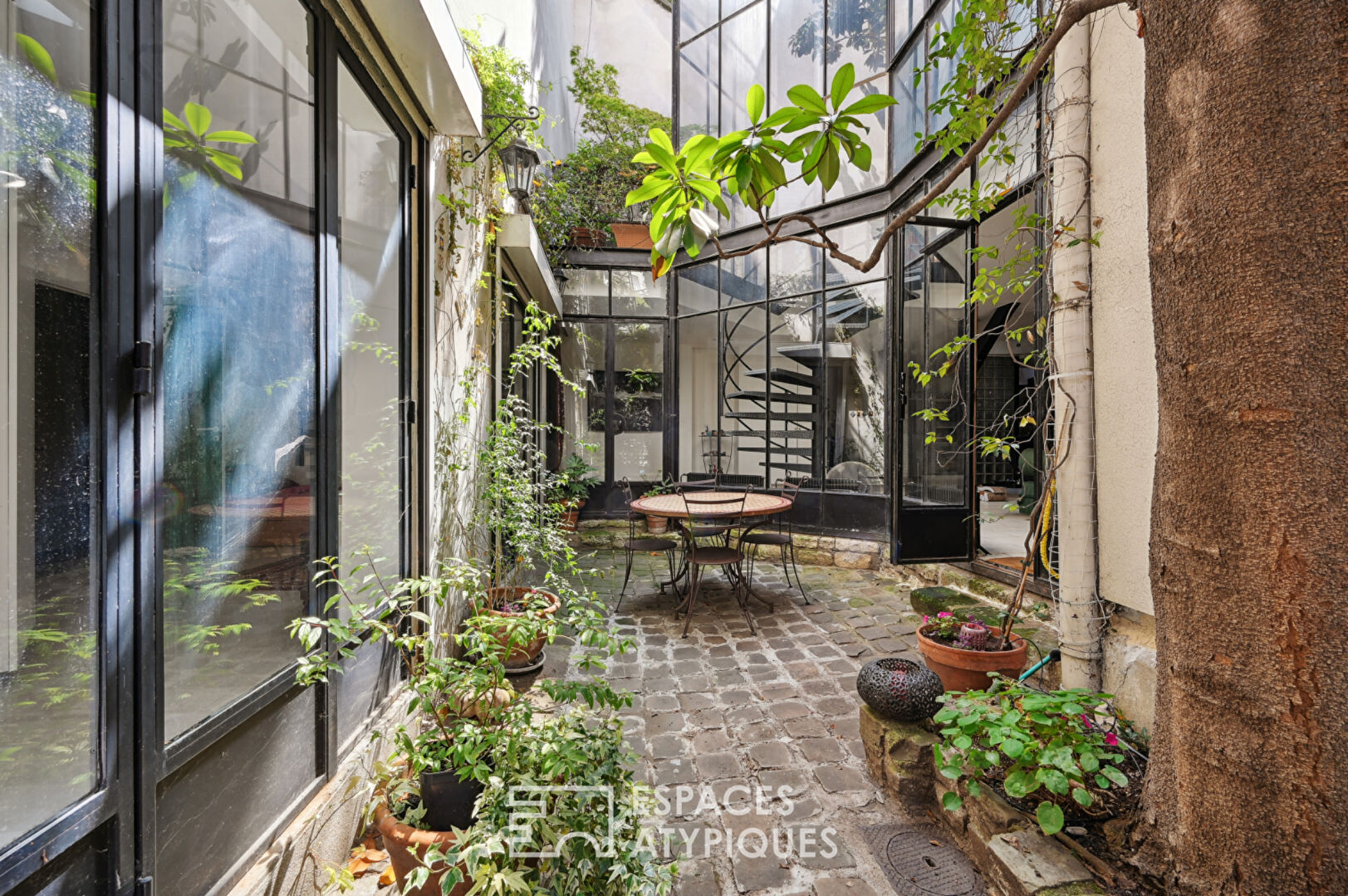 Loft with a glass roof, reminiscent of an artist’s studio, overlooking a courtyard and terrace near the Jardin des Plantes