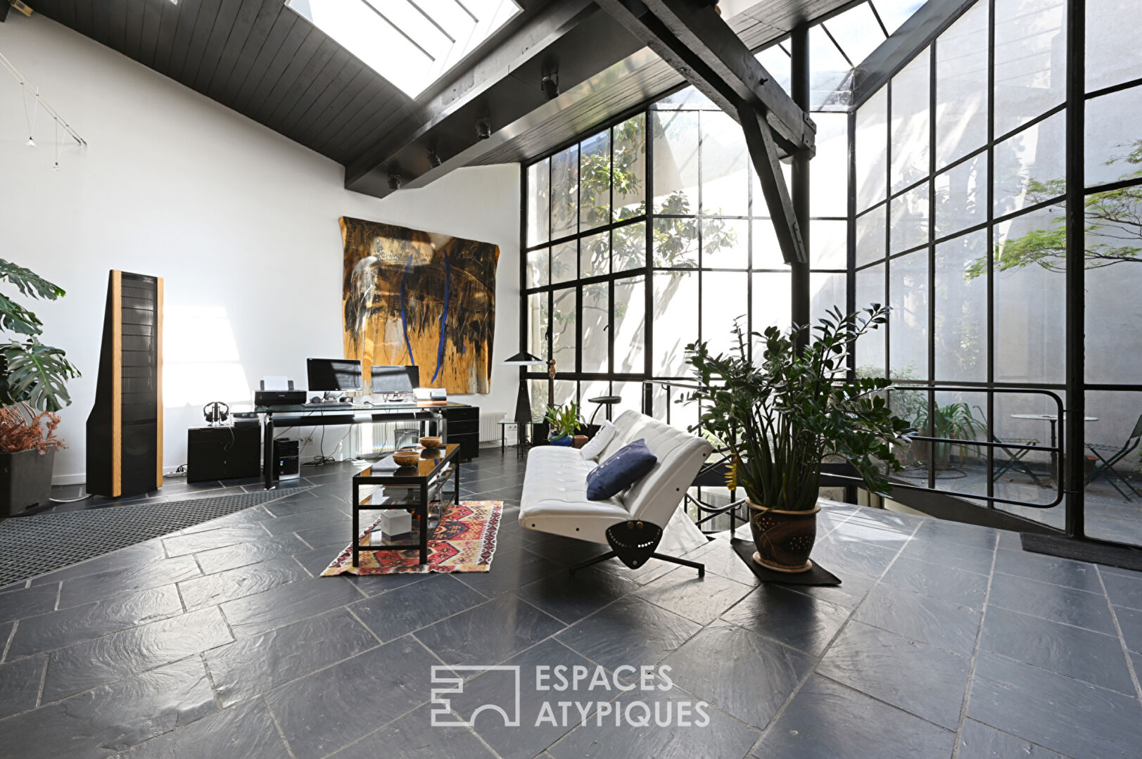 Loft with a glass roof, reminiscent of an artist’s studio, overlooking a courtyard and terrace near the Jardin des Plantes