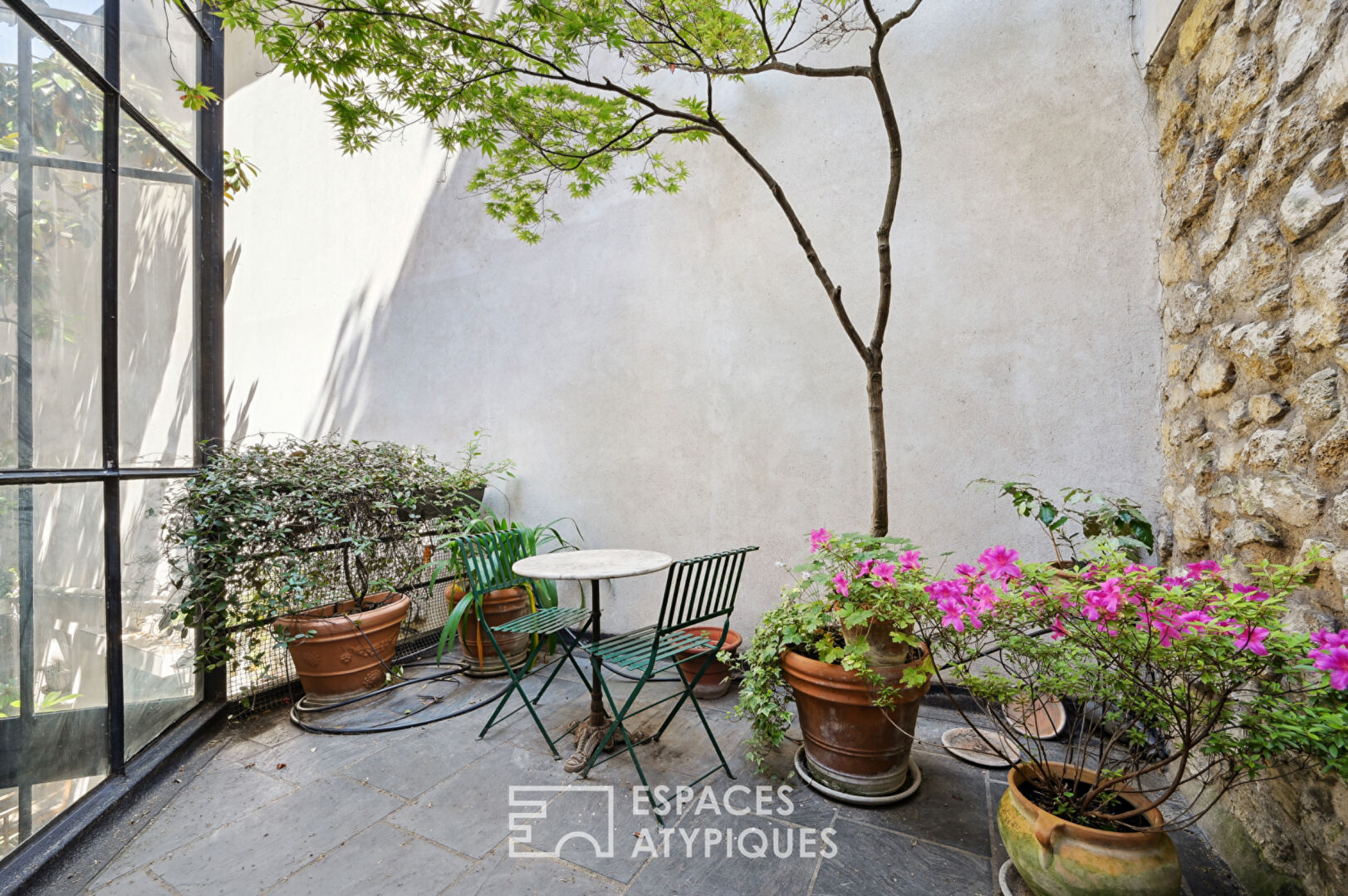 Loft with a glass roof, reminiscent of an artist’s studio, overlooking a courtyard and terrace near the Jardin des Plantes