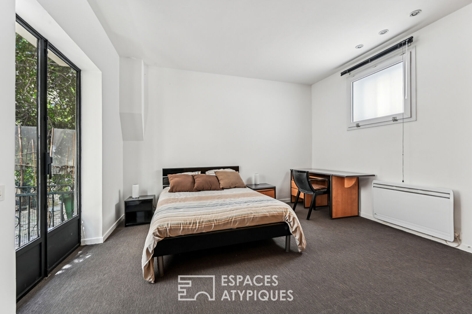 Loft with a glass roof, reminiscent of an artist’s studio, overlooking a courtyard and terrace near the Jardin des Plantes