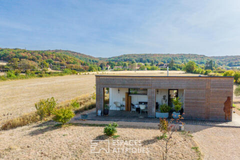 Timber-framed house harmoniously integrated into nature