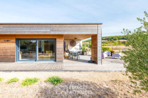 Timber-framed house harmoniously integrated into nature