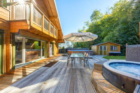 Maison en bois et sa piscine en bordure de forêt
