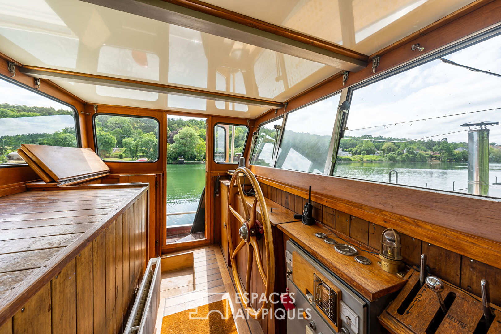 Large and bright barge on the banks of the Seine with terrace