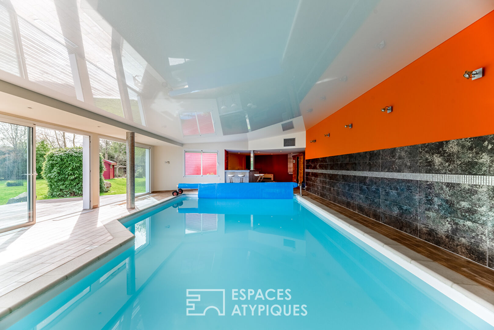 Maison d’architecte avec piscine intérieure sur terrain paysagé