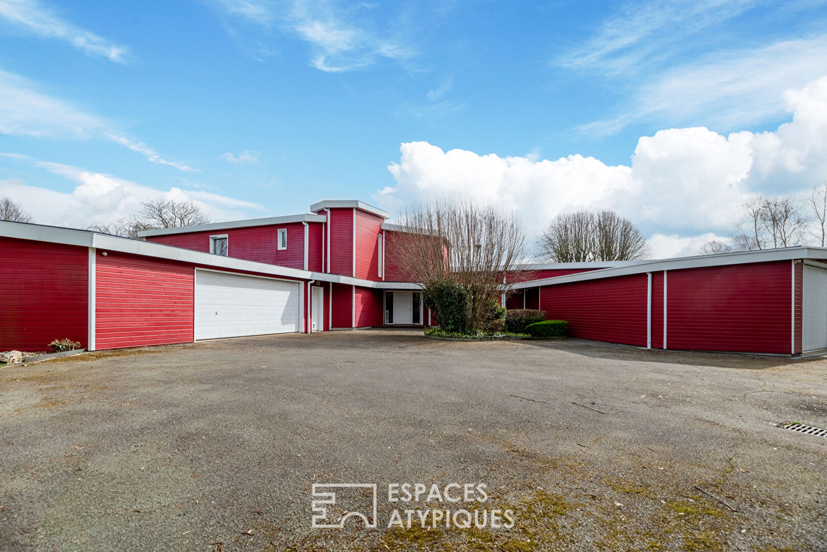 Maison d’architecte avec piscine intérieure sur terrain paysagé