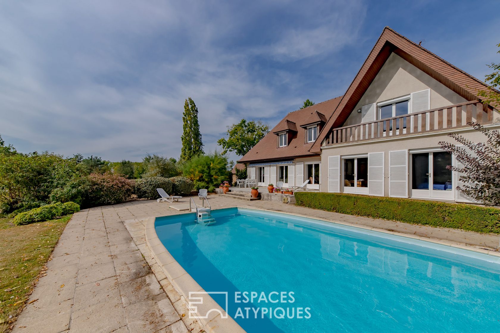 Architect house from the 70s in its park with swimming pool.