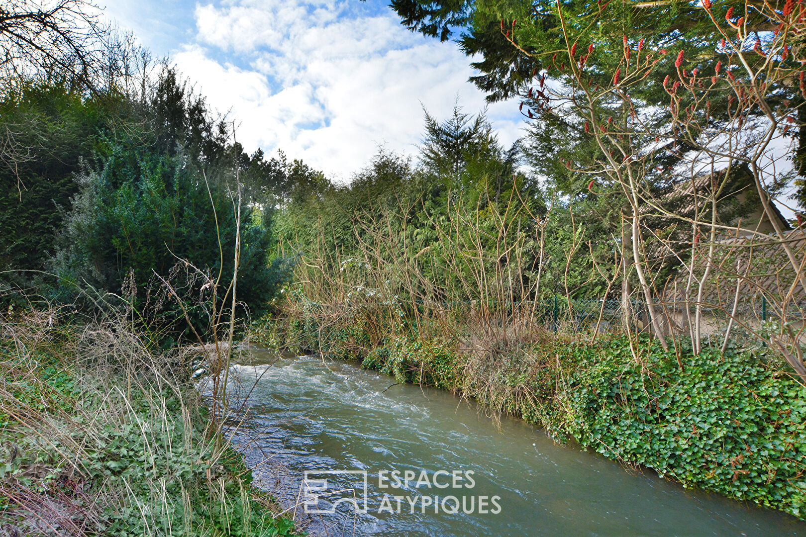 Longère style house bordered by a river