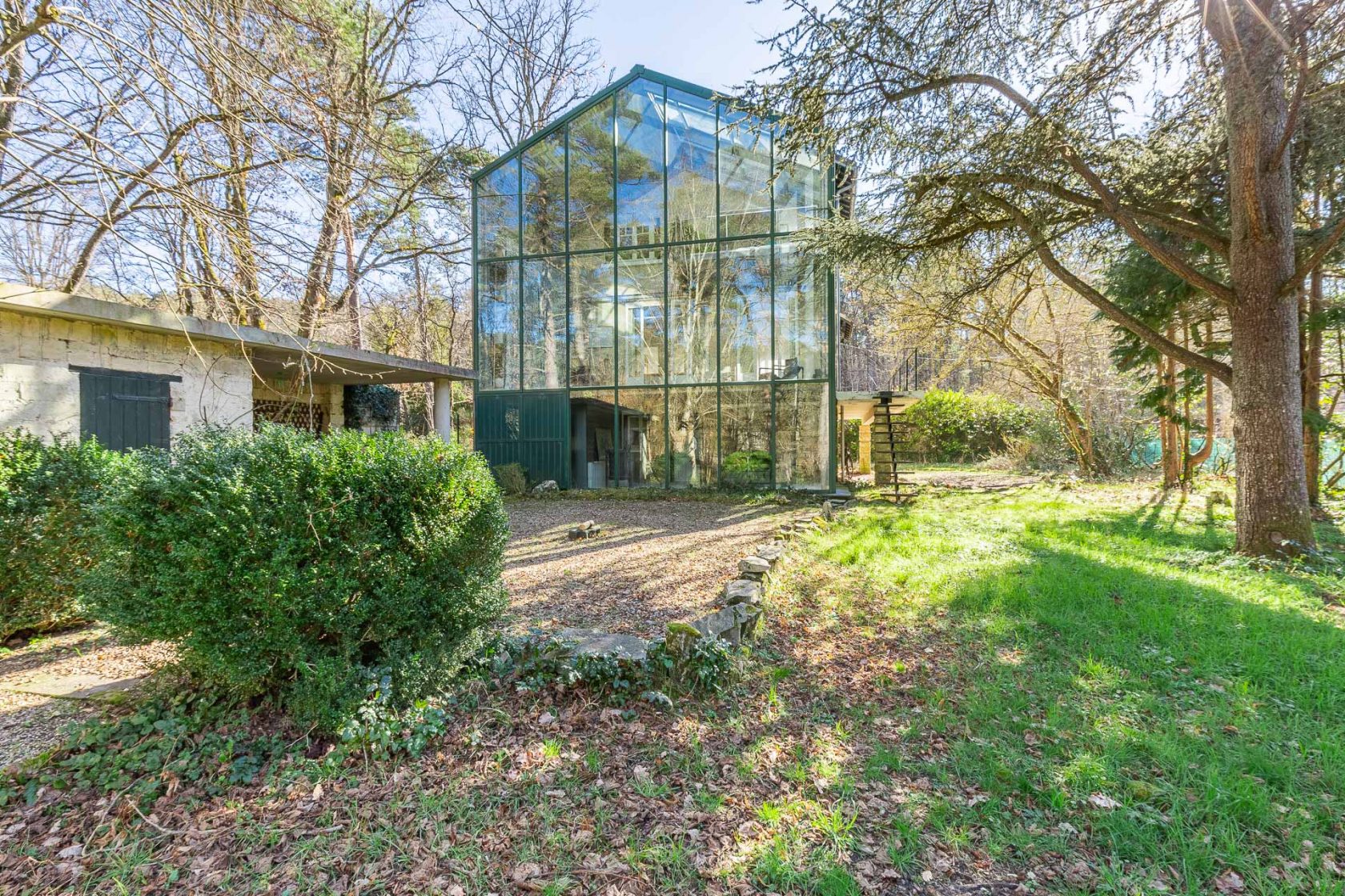 House with its glass extension nestled in the forest