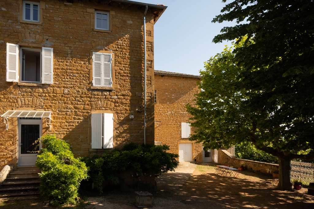 Golden stone building with swimming pool and outbuilding