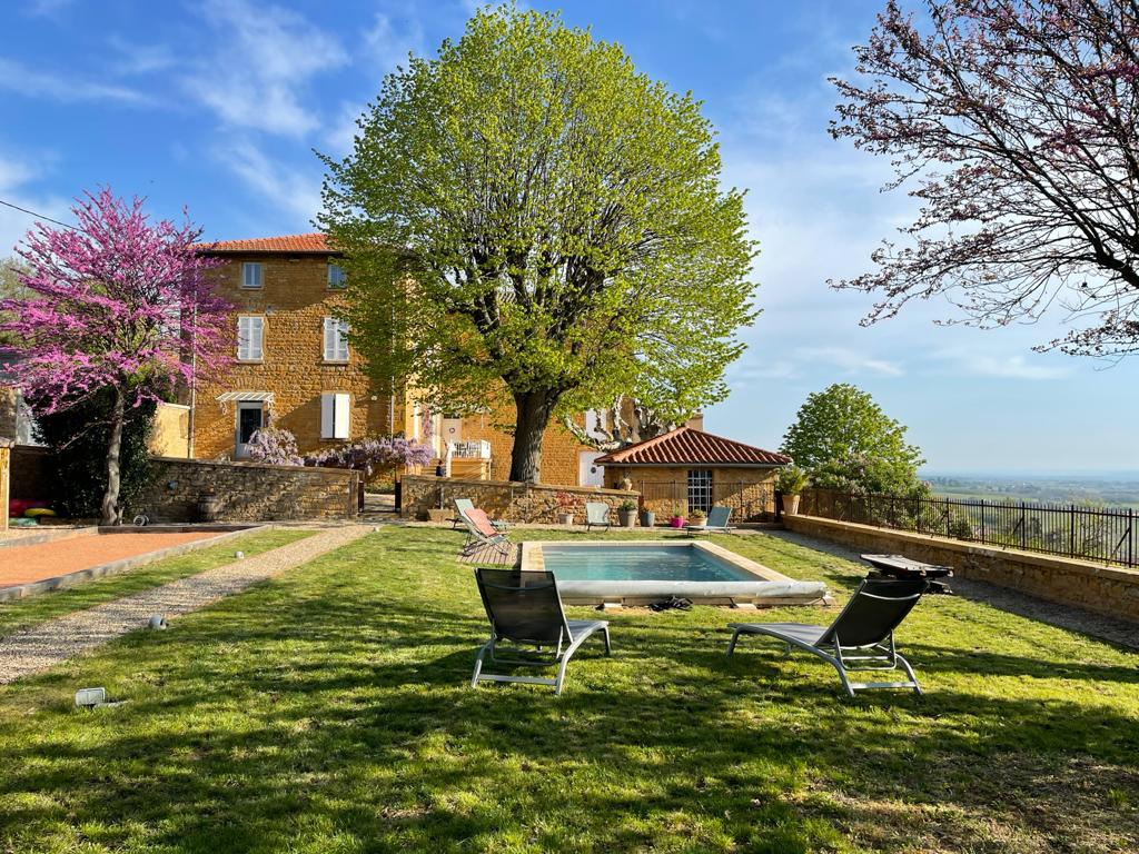 Golden stone building with swimming pool and outbuilding