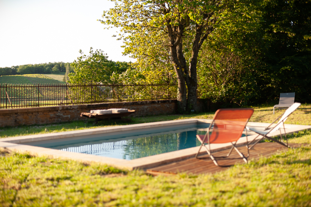 Golden stone building with swimming pool and outbuilding