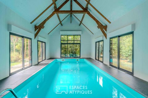 Villa contemporaine avec piscine intérieure dans un écrin de verdure.