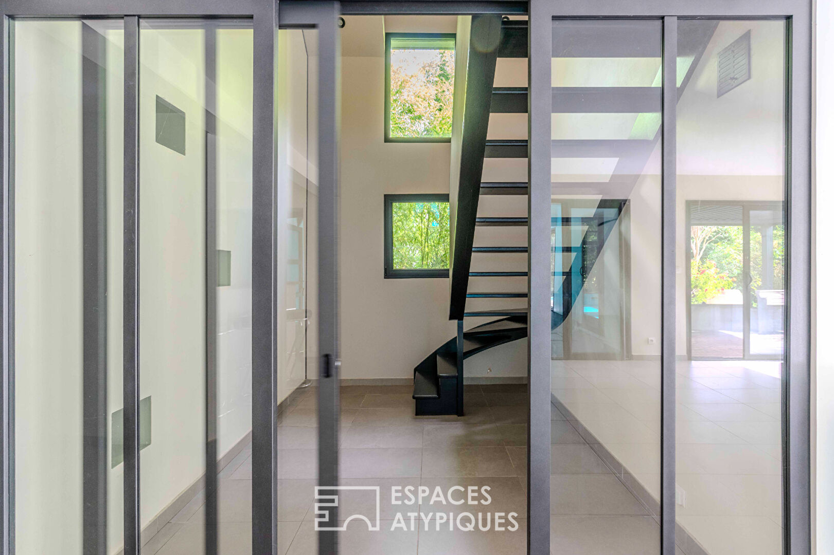 Villa contemporaine avec piscine intérieure dans un écrin de verdure.