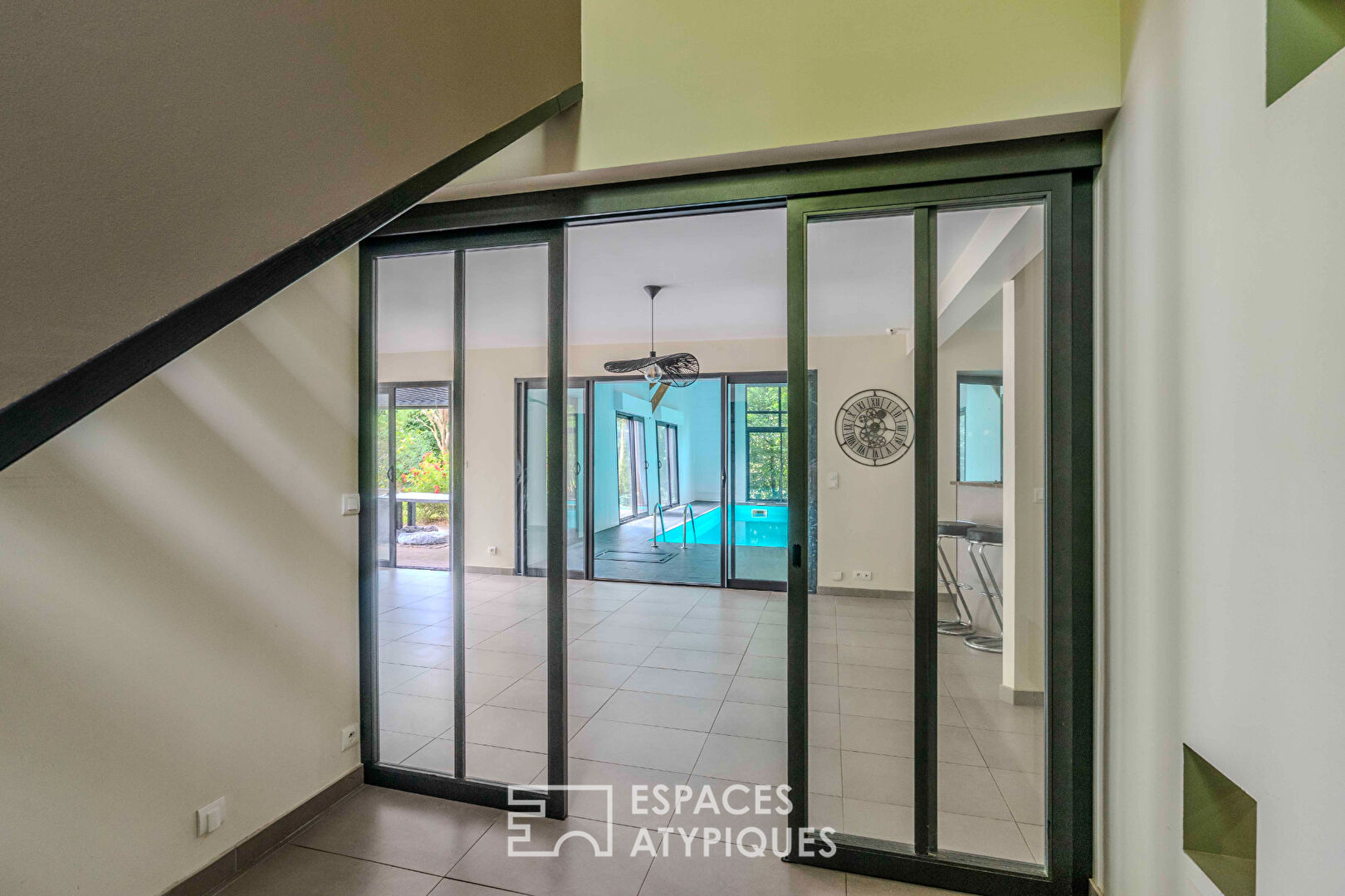 Villa contemporaine avec piscine intérieure dans un écrin de verdure.