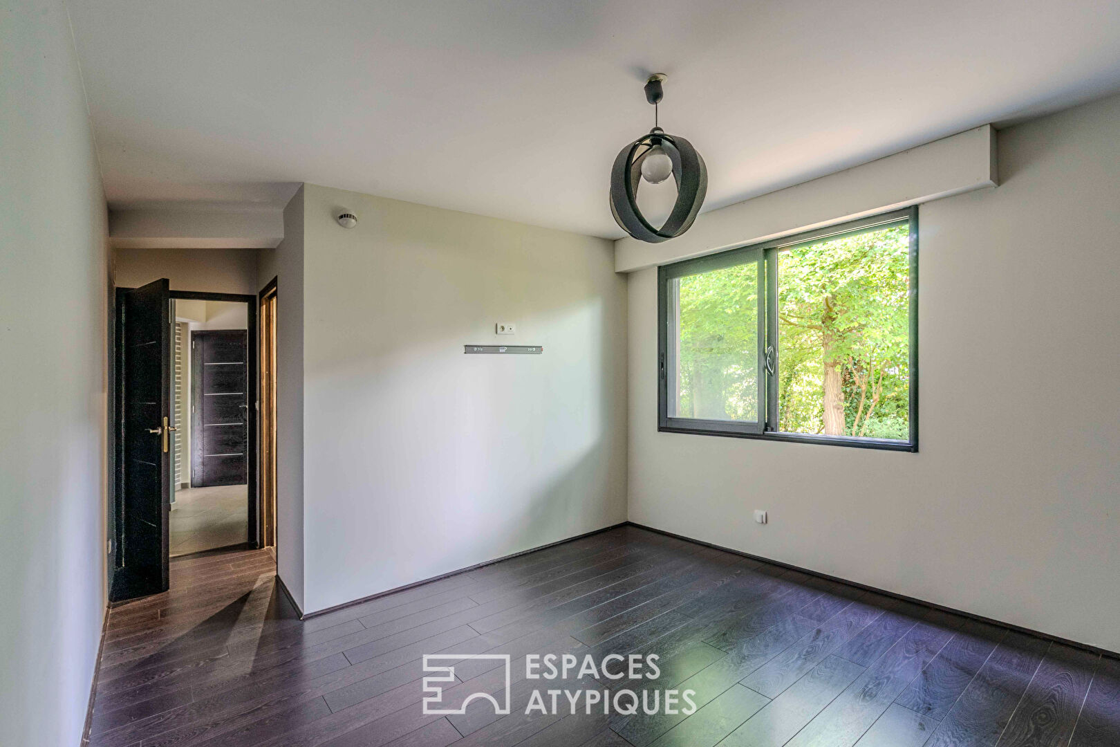 Villa contemporaine avec piscine intérieure dans un écrin de verdure.