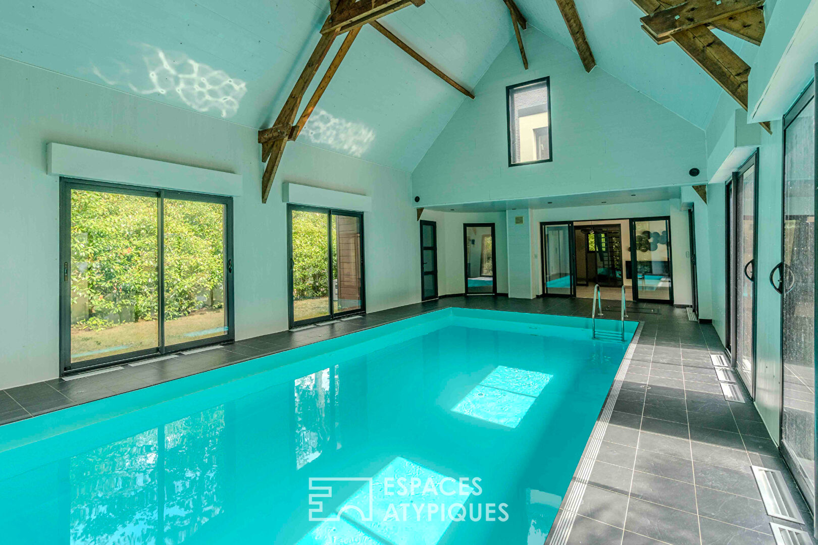 Villa contemporaine avec piscine intérieure dans un écrin de verdure.