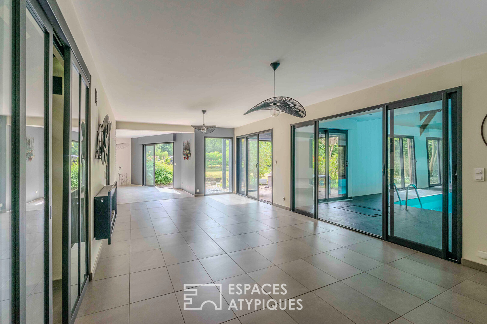 Villa contemporaine avec piscine intérieure dans un écrin de verdure.