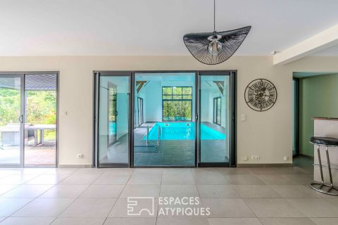 Villa contemporaine avec piscine intérieure dans un écrin de verdure.