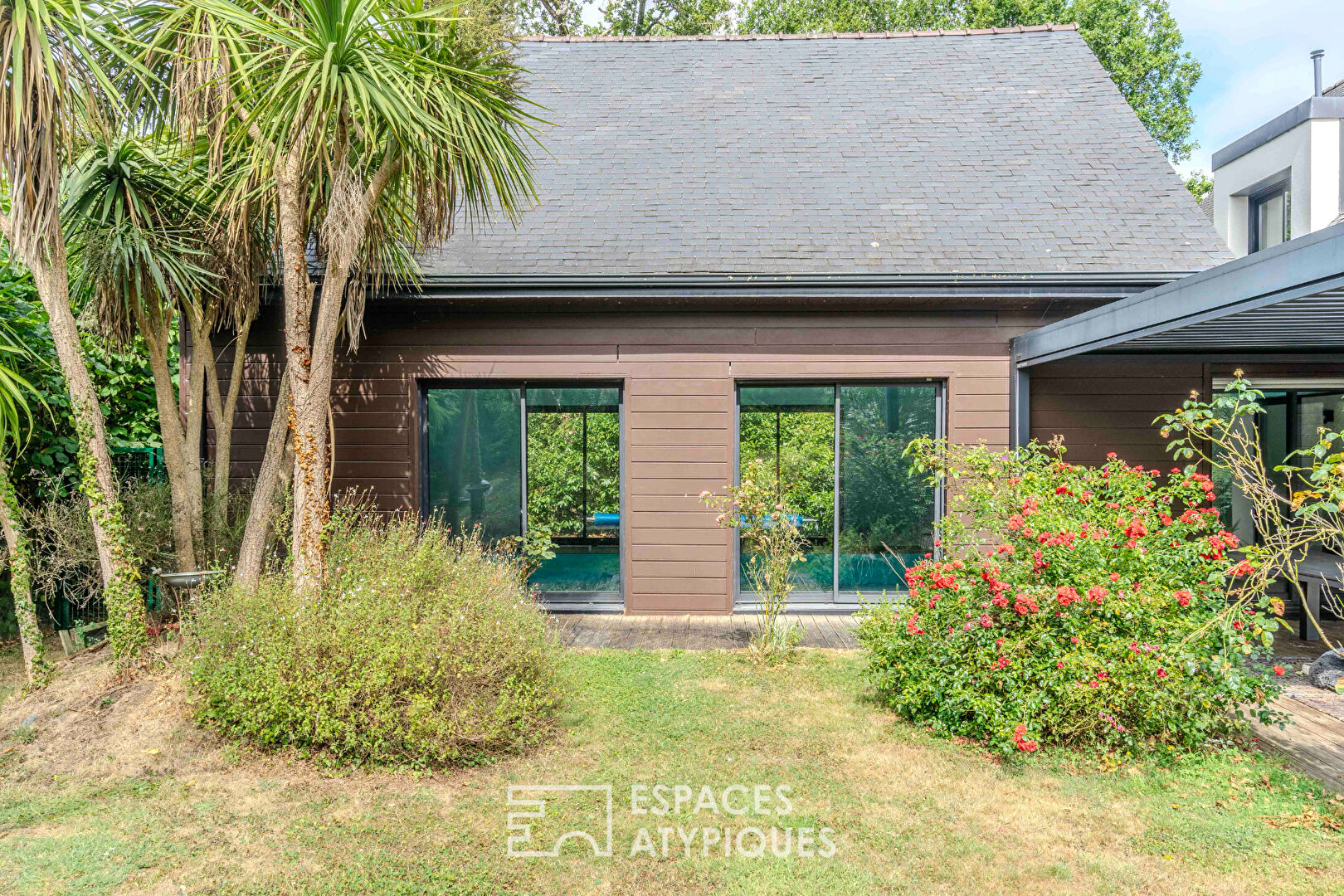 Villa contemporaine avec piscine intérieure dans un écrin de verdure.