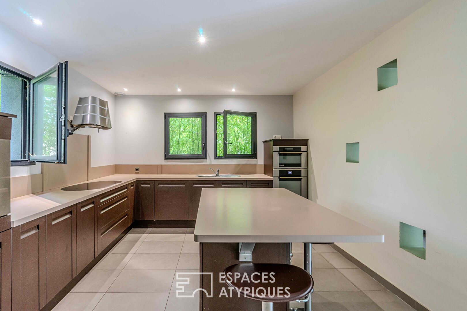 Villa contemporaine avec piscine intérieure dans un écrin de verdure.