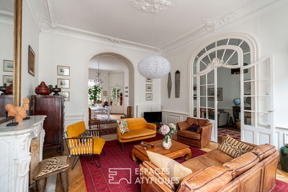 salon d'un appartement haussmannien avec cheminée en marbre, parquet et moulures.
