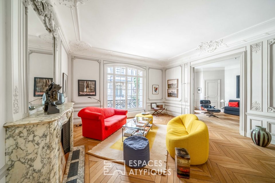 salon d'un appartement haussmannien avec cheminée en marbre, parquet et moulures.