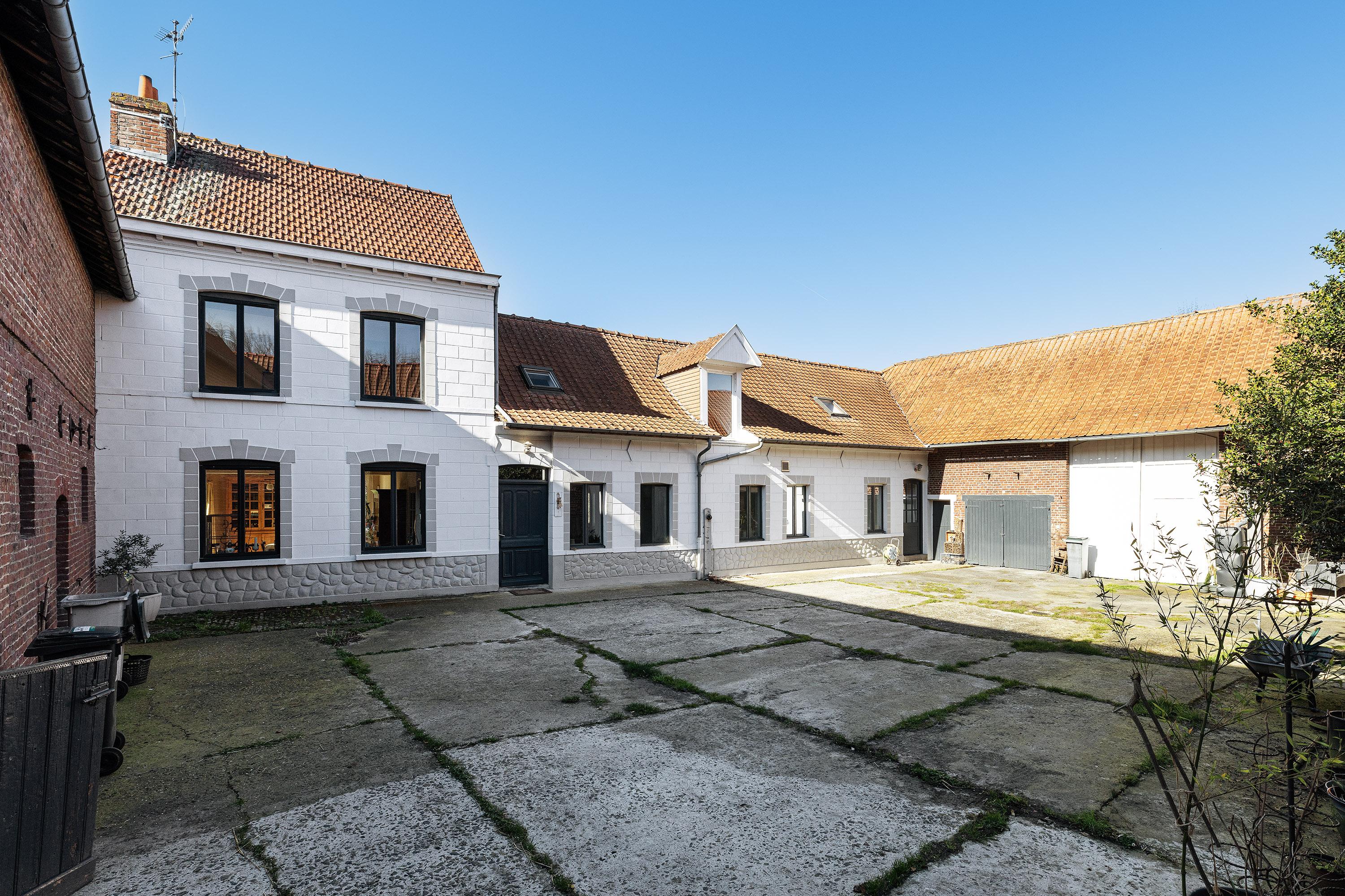 An old square farmhouse in the heart of the fields