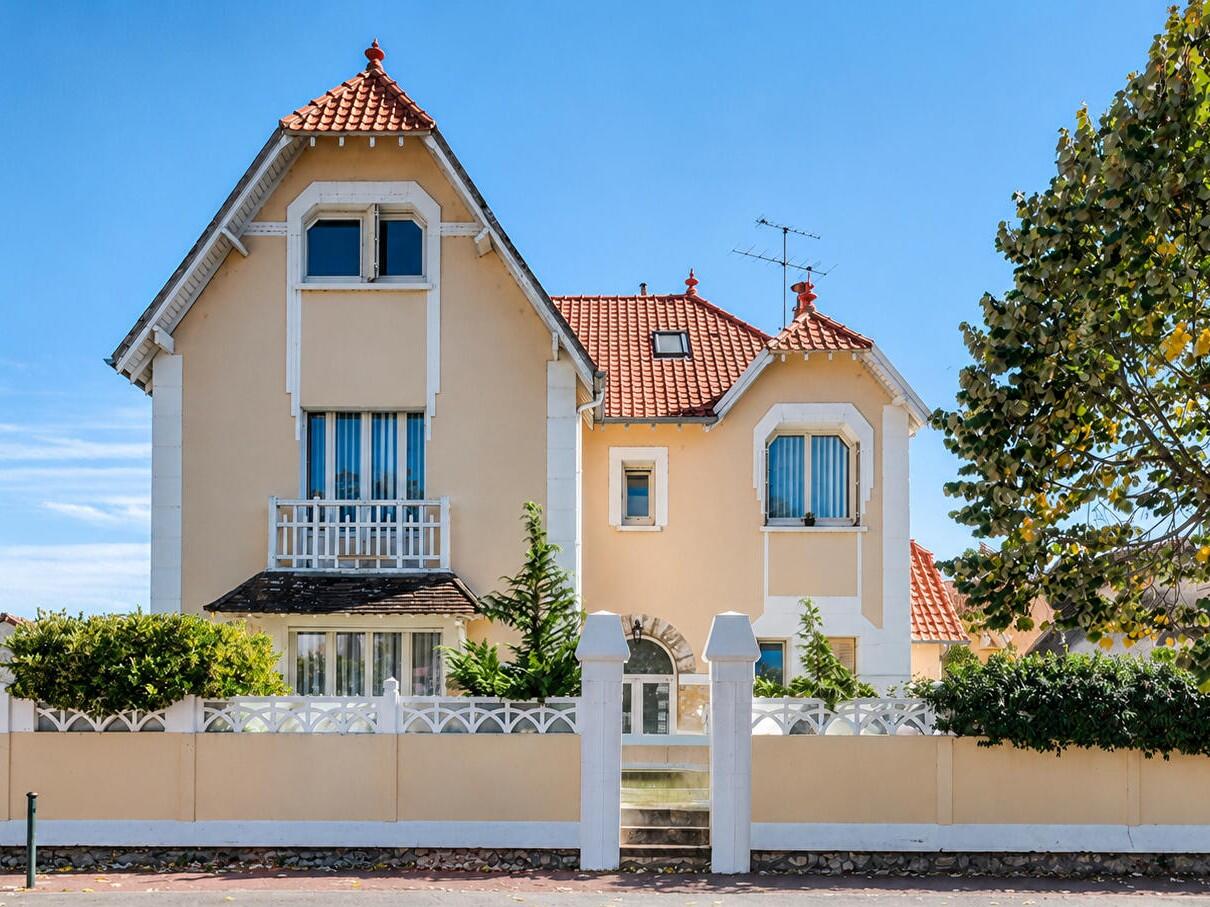 Façade de maison bourgeoise à Étampes avec toits pointus en tuiles, balcon et grille sur rue