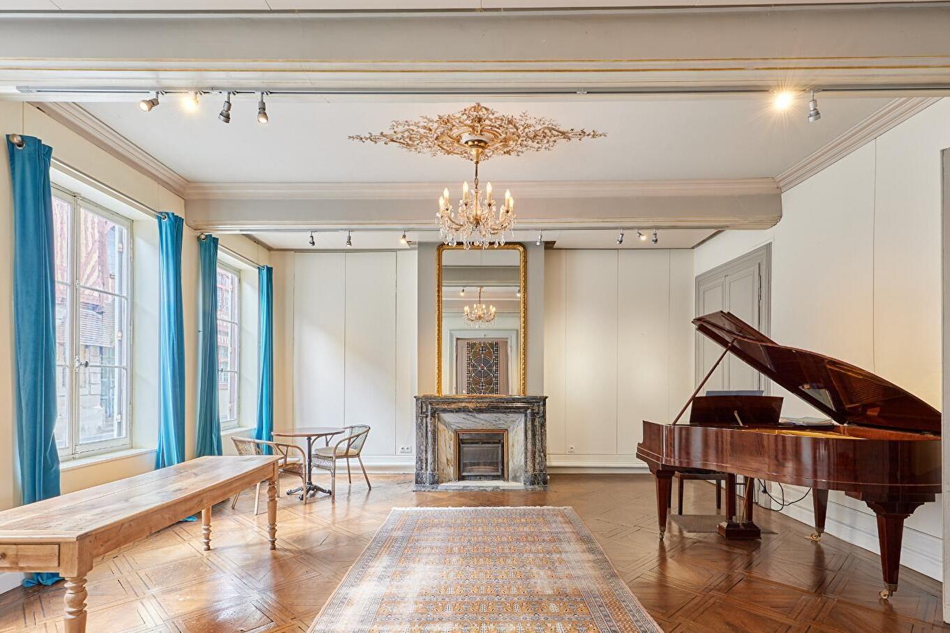 Salon de réception d'un manoir avec moulures, cheminée en marbre, parquet ancien et grande hauteur sous plafond
