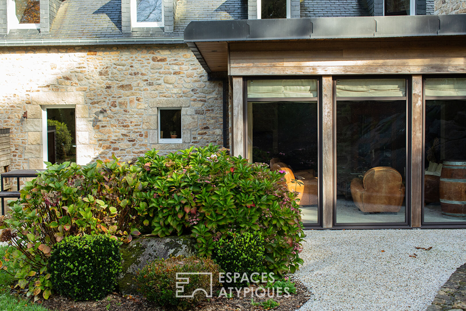 En bord de rivière, maison de caractère en pierre au milieu de la nature