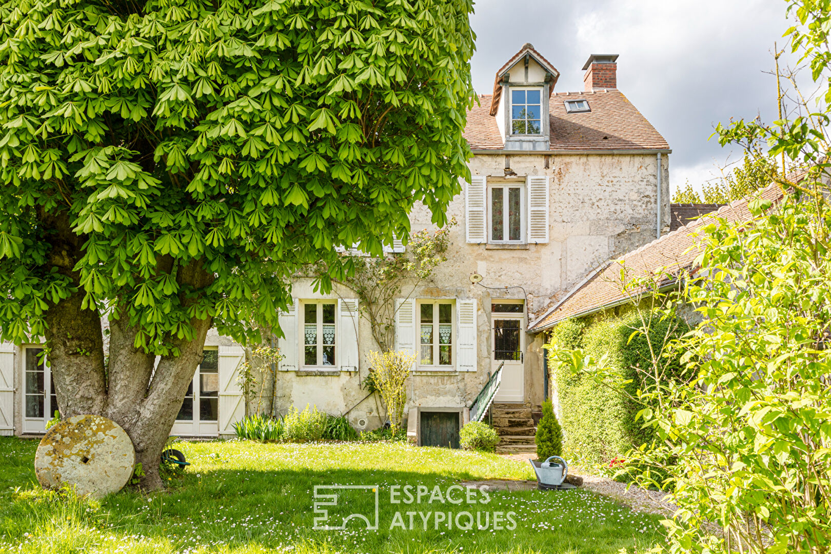 Large stone property, nestled behind its wisteria